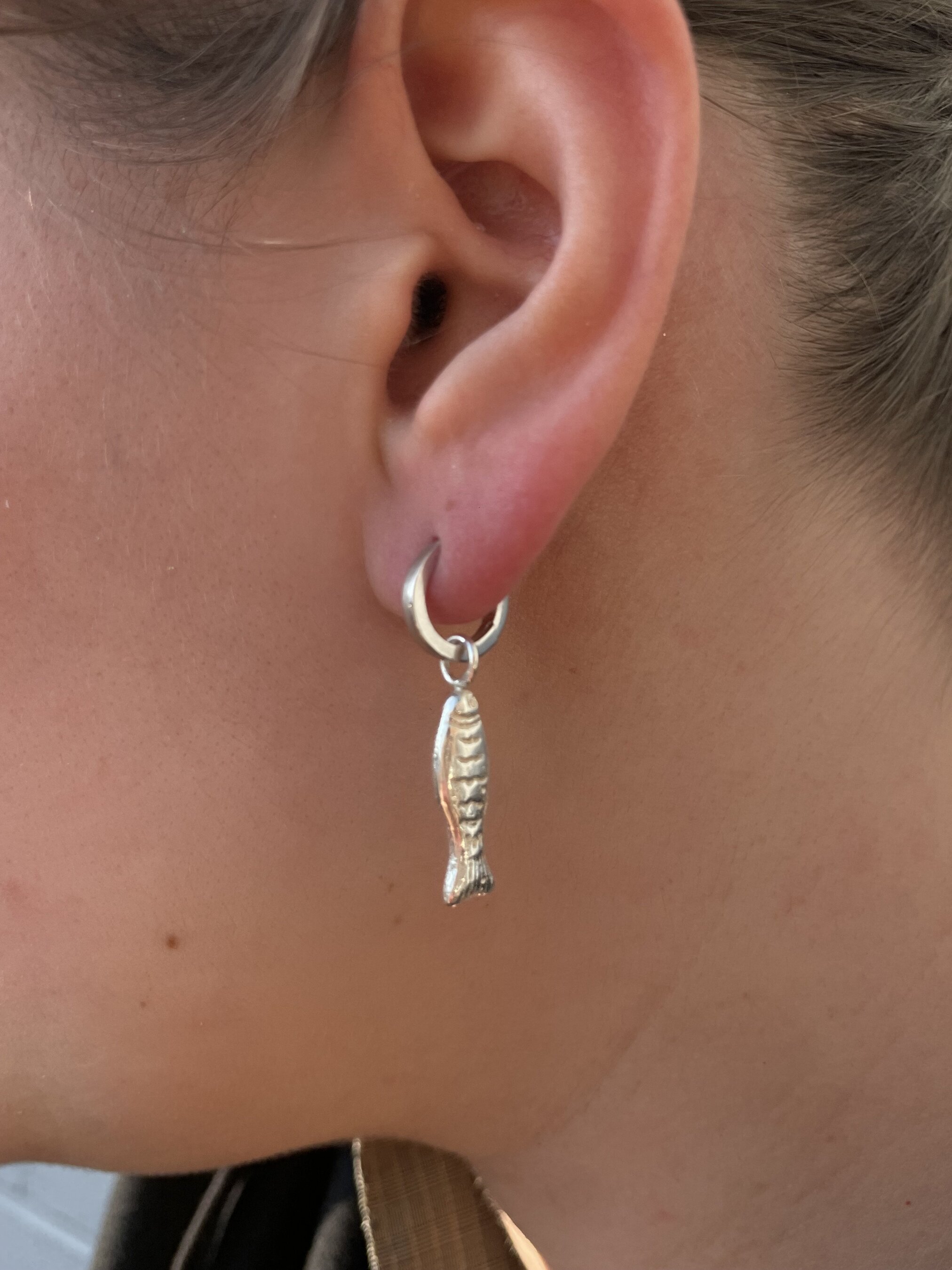 Fish charm worn on ear